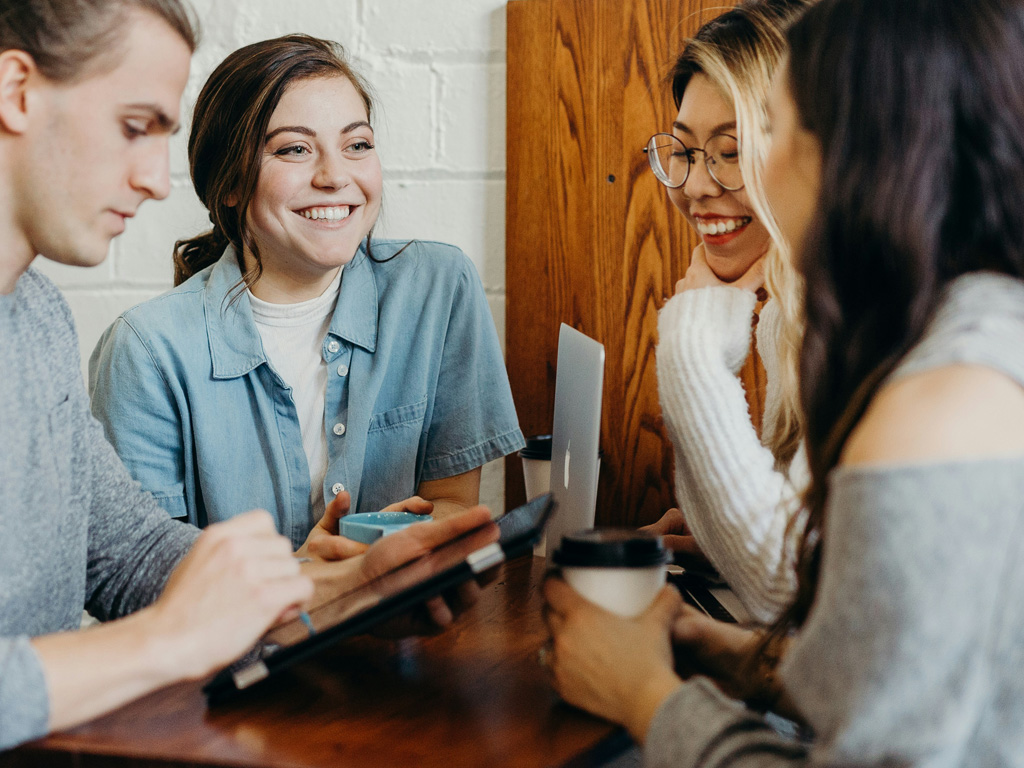 Four SEO professionals strategizing at table image. Photo by Brooke Cagle on Unsplash.