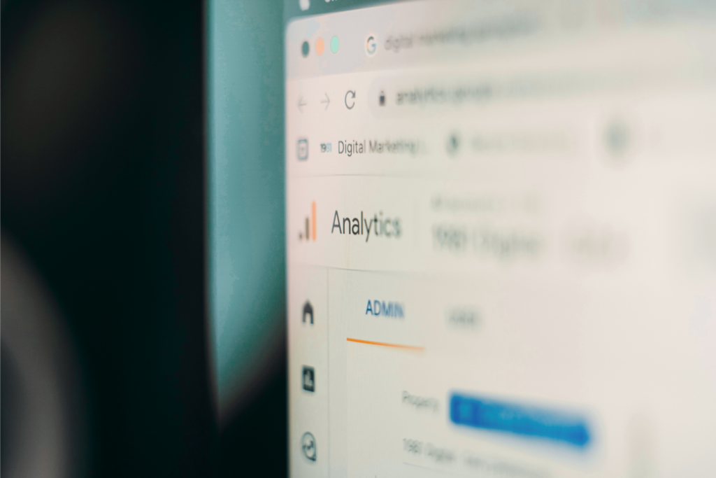 A computer screen shows a blurred view of a web analytics dashboard with the word "Analytics" visible.